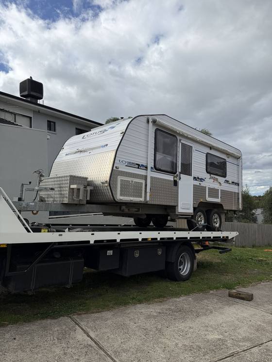 Hilly's truck carrying a caravan on its tilt tray